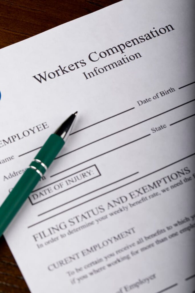 Close-up of workers’ compensation form with a green pen on top