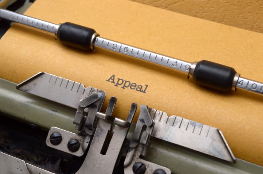 Close-up of a typewriter with a paper in it that says “appeal”