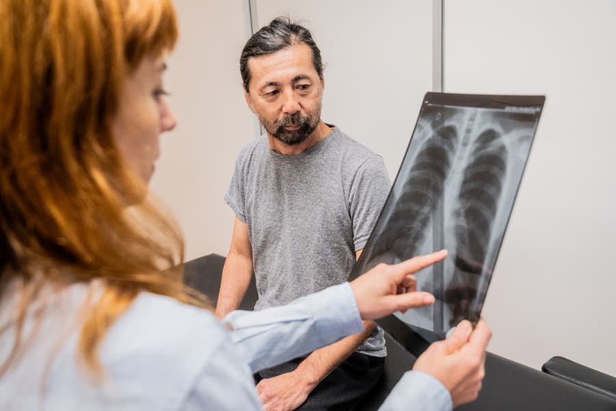 Female doctor showing chest x-ray to male patient