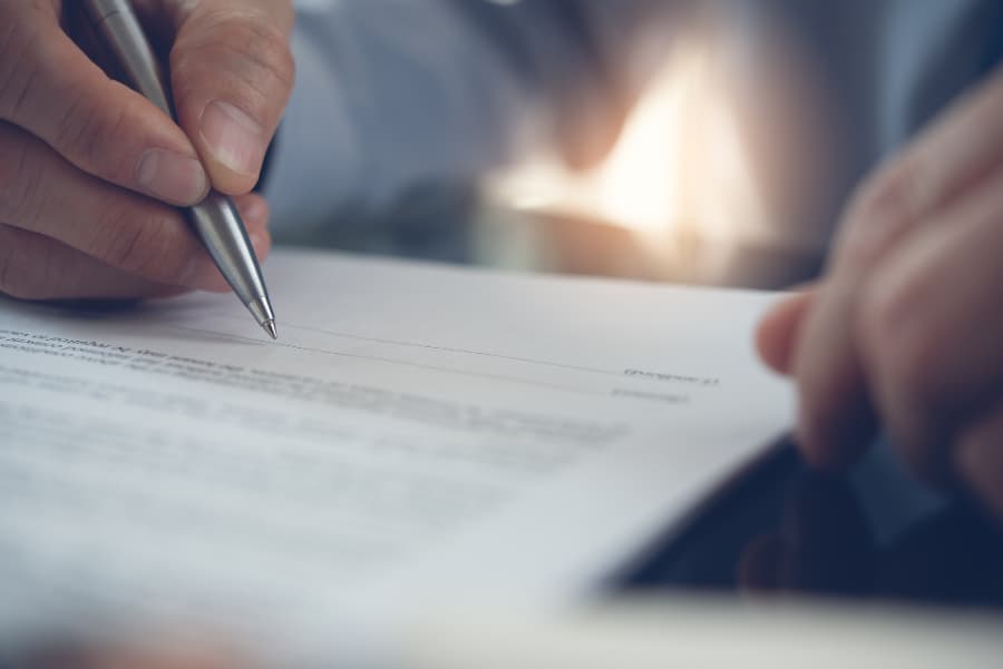Blurred close-up of a man signing a contract